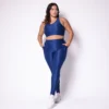 Modelo plus size vestindo o conjunto de Legging de Bolso e Top Clara feito em tecido aveludado de compressão, na cor azul night blue