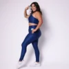 Modelo plus size vestindo o conjunto de Legging de Bolso e Top Clara feito em tecido aveludado de compressão, na cor azul night blue