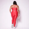 Modelo plus size vestindo o conjunto de Legging de Bolso e Top Clara feito em tecido aveludado de compressão, na cor vermelho