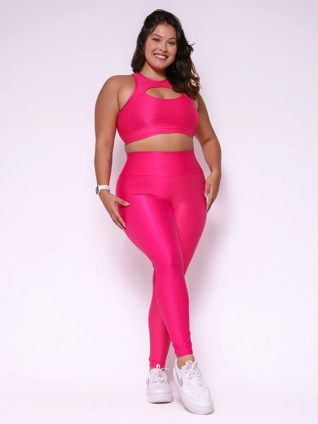 Modelo plus size vestindo o conjunto de Legging Clássica e Top Anne feito em tecido Aveludado de compressão, na cor rosa pink