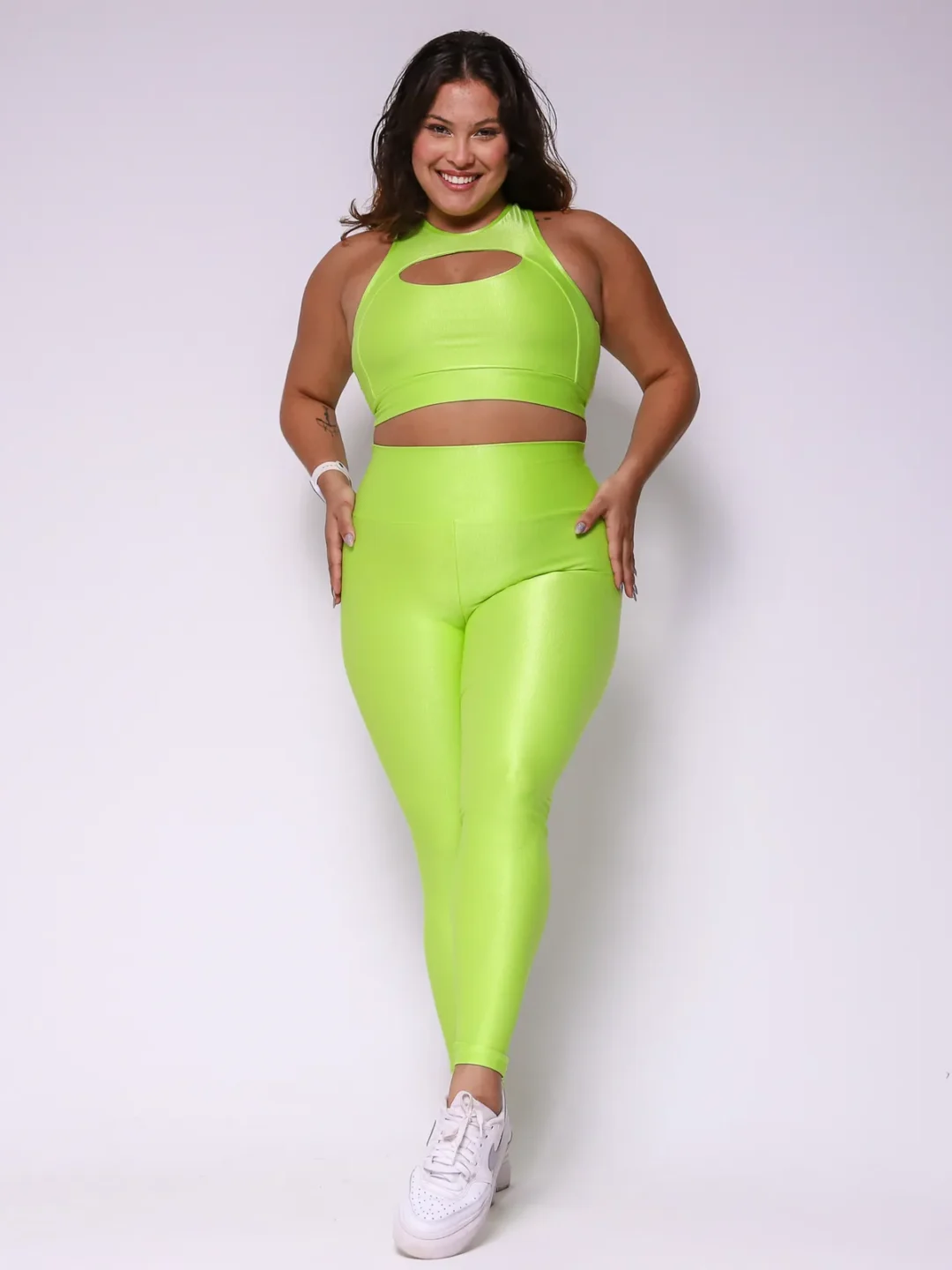 Modelo plus size vestindo o conjunto de Legging Clássica e Top Anne feito em tecido Aveludado de compressão, na cor verde citrus