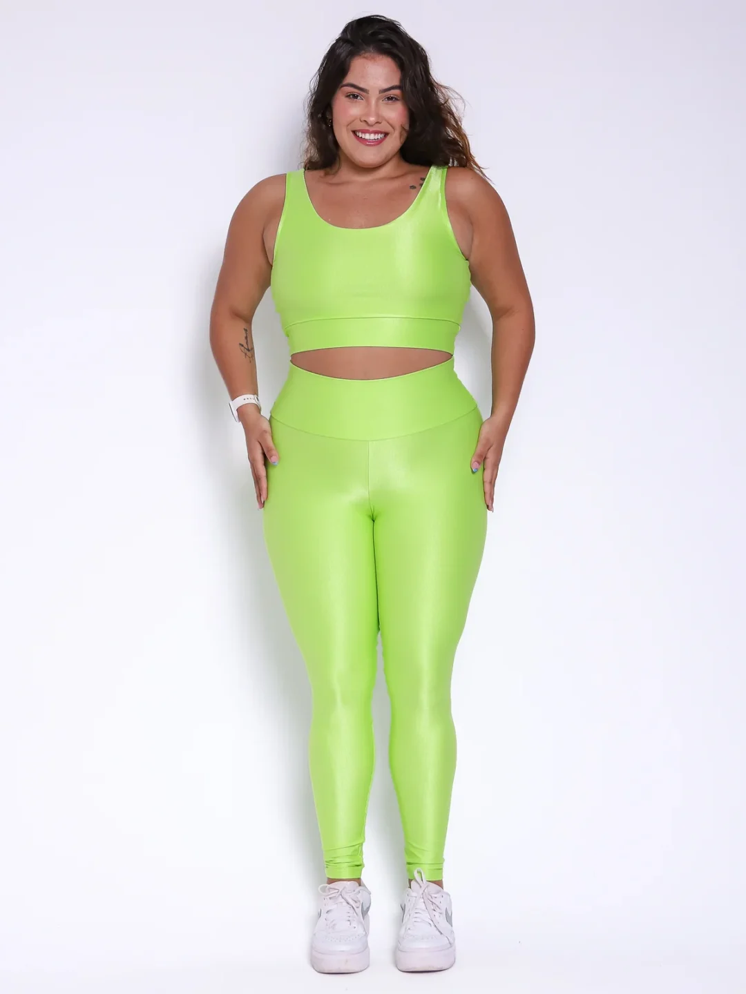 Modelo plus size vestindo o conjunto de Legging Clássica e Top bia feito em tecido Aveludado de compressão, na cor verde citrus