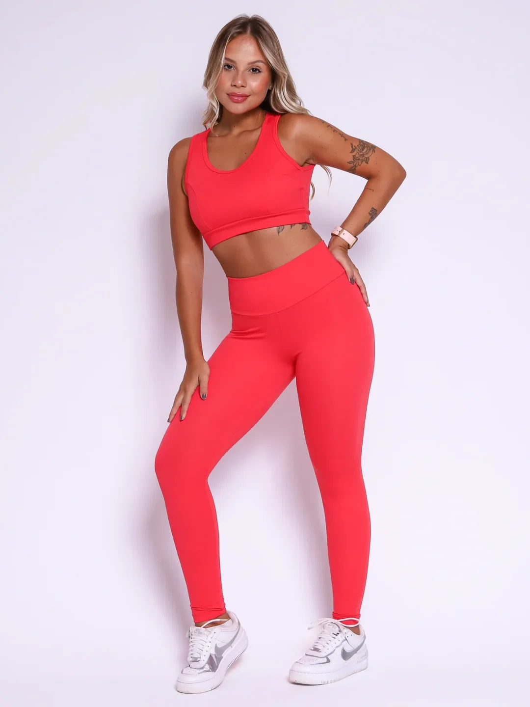 Modelo vestindo o conjunto de Legging Clássica e Top Liss Jacquard Spot feito em tecido jacquard, com textura spot, na cor vermelho